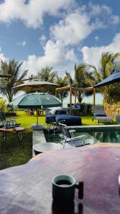 ein Tisch mit einer Tasse Kaffee auf einem Tisch mit Sonnenschirmen in der Unterkunft MHV Milagres - Casa OKA 37 in Passo de Camarajibe