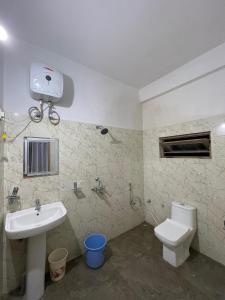 a bathroom with a sink and a toilet at Drukinn gaireykhet homestay in Thode