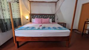 - une chambre dotée d'un grand lit avec des oreillers roses et bleus dans l'établissement Rekawa Edge villa, à Netolpitiya 7 autres photos