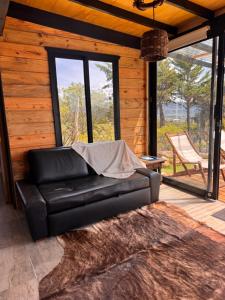 een zwarte leren bank in een kamer met een patio bij Minicasas La Villa in Santa Sofía