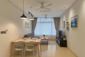 クアラルンプールにあるSky Suites KLCC By Tomのテーブルと椅子のあるダイニングルームとリビングルーム