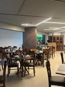 a dining room with wooden tables and chairs at ArqSuites Berrini WTC SP - Suíte privada dentro do Hotel in São Paulo