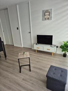 a living room with a tv and a table at modern apartment excellent location coquimbo in Coquimbo