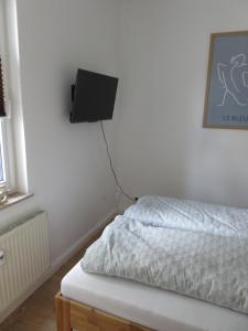a bedroom with a bed and a tv on the wall at Wohnung am Tor zur Lewitz-Erdgeschoss in Banzkow