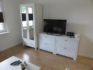 a white dresser with a television on top of it at Wohnung am Tor zur Lewitz-Erdgeschoss in Banzkow