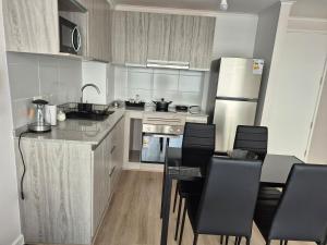 a kitchen with a table and chairs and a refrigerator at modern apartment excellent location coquimbo in Coquimbo