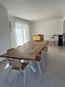 a large wooden table with chairs in a room at Maison proche plage avec parking in Wimereux