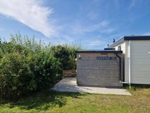 a garage with a sign on it next to a building at Zeester in Ameland