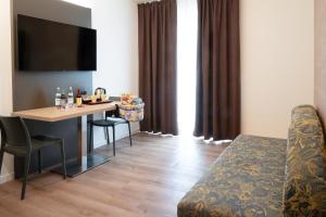 Habitación de hotel con mesa y cama en Ambassador Suite Hotel, en Riva del Garda