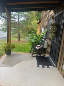 a porch with a chair on the side of a house at Little cottage by the cabin in Springfield