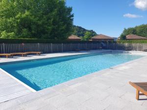 a swimming pool with benches next to a fence at Lac des Graves in Lascelle