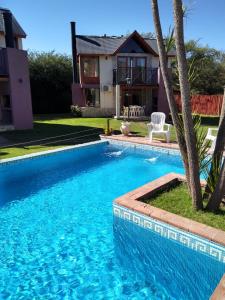 a swimming pool in front of a house at Cabañas Ayres del Lago in Potrero de los Funes