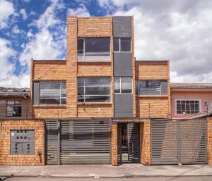 a brick building with windows and a garage at The Andes apartment Patio & Luxury in Cuenca