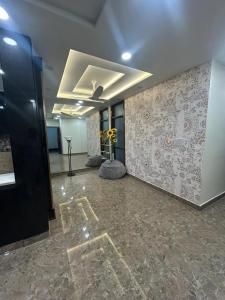 una habitación vacía con una pared con flores. en Noori, en Agra