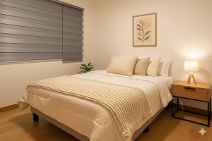 a bedroom with a large white bed with a window at The Andes apartment Patio & Luxury in Cuenca