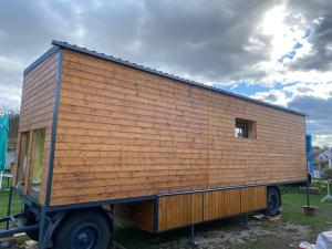 a large wooden house on the back of a truck at Útulná maringotka v srdci Šumavy in Borová Lada