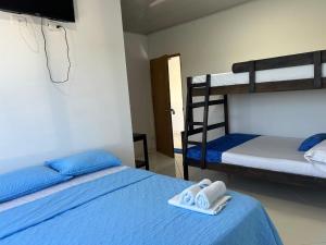 a bedroom with two bunk beds with towels and a television at Hotel mirador Dubai in San Antero +2 photos