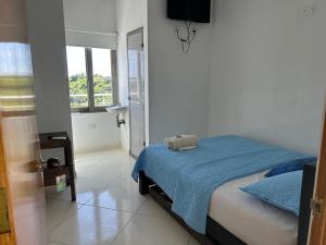 a bedroom with a bed with a blue blanket at Hotel mirador Dubai in San Antero