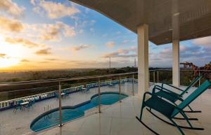 a balcony with a chair and a swimming pool at Hotel mirador Dubai in San Antero