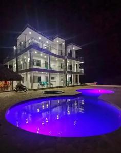 a large house at night with a large swimming pool at Hotel mirador Dubai in San Antero