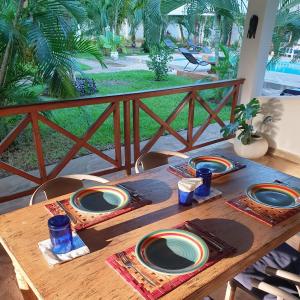 einem Holztisch mit Platten darüber in der Unterkunft Diani Gardens Cottage in Ukunda Airport + 6 Fotos