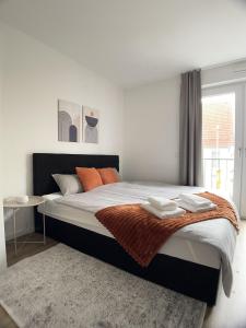 a bedroom with a large bed with orange pillows at Design Vogue Apartment-Zentral-WiFi-4Personen in Metzingen +5 photos