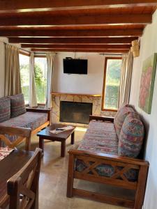 a living room with a couch and a fireplace at Cabañas Ayres del Lago in Potrero de los Funes