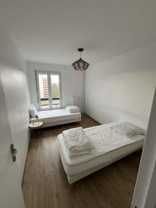 een kamer met twee bedden en een raam bij Appartement spacieux 4 personnes in Charleville-Mézières