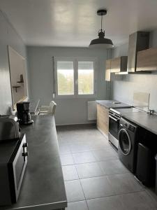 een keuken met een fornuis en een vaatwasser bij Appartement spacieux 4 personnes in Charleville-Mézières