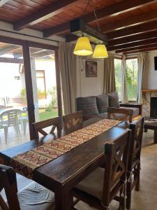 a dining room table and chairs in a living room at Cabañas Ayres del Lago in Potrero de los Funes