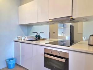 クアラルンプールにあるSky Suites KLCC By Tomの白いキャビネットとシンクのあるキッチン +60枚の写真