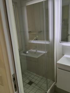 a bathroom with a sink and a glass shower at 1 on albert Luxury apartment in Cape Town