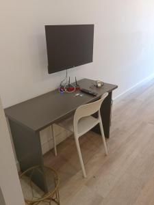 a desk with a computer monitor and a chair at 1 on albert Luxury apartment in Cape Town