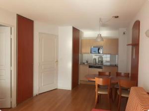 een keuken en eetkamer met een tafel en stoelen bij Hourquette in Bagnères-de-Bigorre