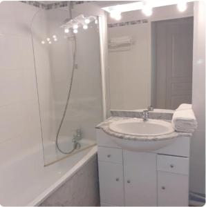 een witte badkamer met een wastafel en een douche bij Hourquette in Bagnères-de-Bigorre