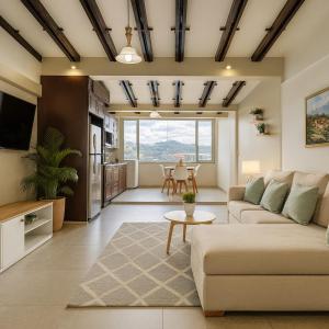 een woonkamer met een bank en een tafel bij Panoramic Loft Unique Windows and Views in Cuenca