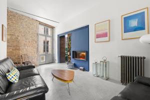 Una sala de estar con un sofá y una chimenea. en The Purple Courtyard, en Beaune