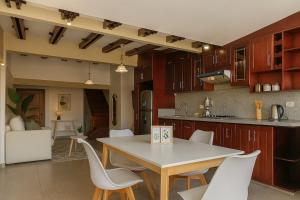 een keuken met een tafel en witte stoelen. bij Panoramic Loft Unique Windows and Views in Cuenca +6 foto's