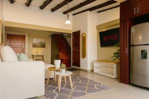 een woonkamer met een witte bank en een keuken bij Panoramic Loft Unique Windows and Views in Cuenca