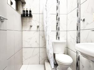 een witte badkamer met een toilet en een wastafel bij Panoramic Loft Unique Windows and Views in Cuenca