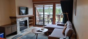 a living room with a couch and a fireplace at Le Grand R in Saint-Donat-de-Montcalm