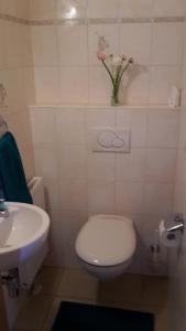 Un baño con inodoro y lavabo con un jarrón de flores. en ZeitVergessen, en Krummhörn 6 fotos más