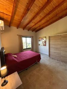 a bedroom with a red bed and a window at Refugio de las nubes in Las Rabonas +10 photos