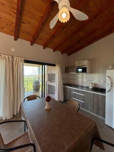 a kitchen with a table with chairs and a refrigerator at Refugio de las nubes in Las Rabonas