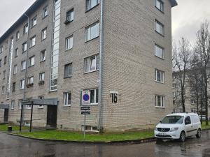 a white van parked in front of a brick building at Gerassimovi 16 in Narva