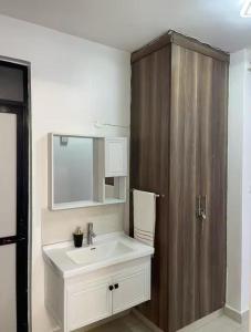 a bathroom with a sink and a wooden cabinet at Serene Homes in Nairobi