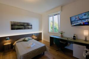 a bedroom with a bed and a desk and a computer at Camera Denver - La Casa di Carta Affittacamere in Udine