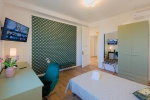 a room with a bed and a desk and a table at Camera Denver - La Casa di Carta Affittacamere in Udine