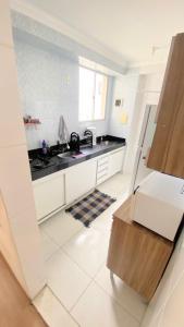 eine weiße Küche mit einer Spüle und einer Theke in der Unterkunft Apartamento completo próximo ao aeroporto CNF cidade do galo e cidade adm in Vespasiano + 4 Fotos