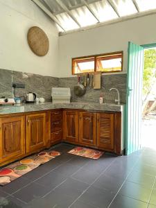 a kitchen with wooden cabinets and a sink at Amurasan beach studio in Tangalle